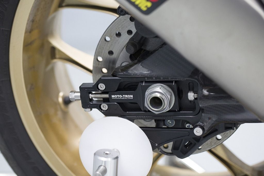 Close-up of a motorcycle suspension system with 'Moto-TRON' branding.